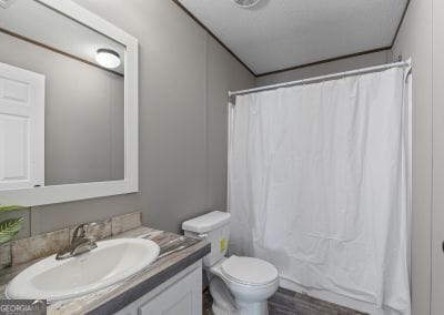 full bathroom with hardwood / wood-style flooring, vanity, shower / bath combination with curtain, and toilet