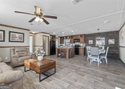 living room featuring ceiling fan with notable chandelier, light hardwood / wood-style floors, and ornamental molding