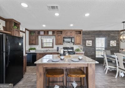 kitchen with light stone counters, a center island, black appliances, and dark hardwood / wood-style floors