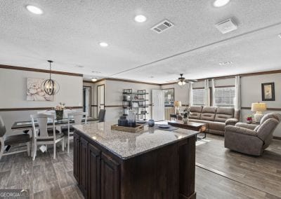 kitchen with light stone counters, decorative light fixtures, and ornamental molding