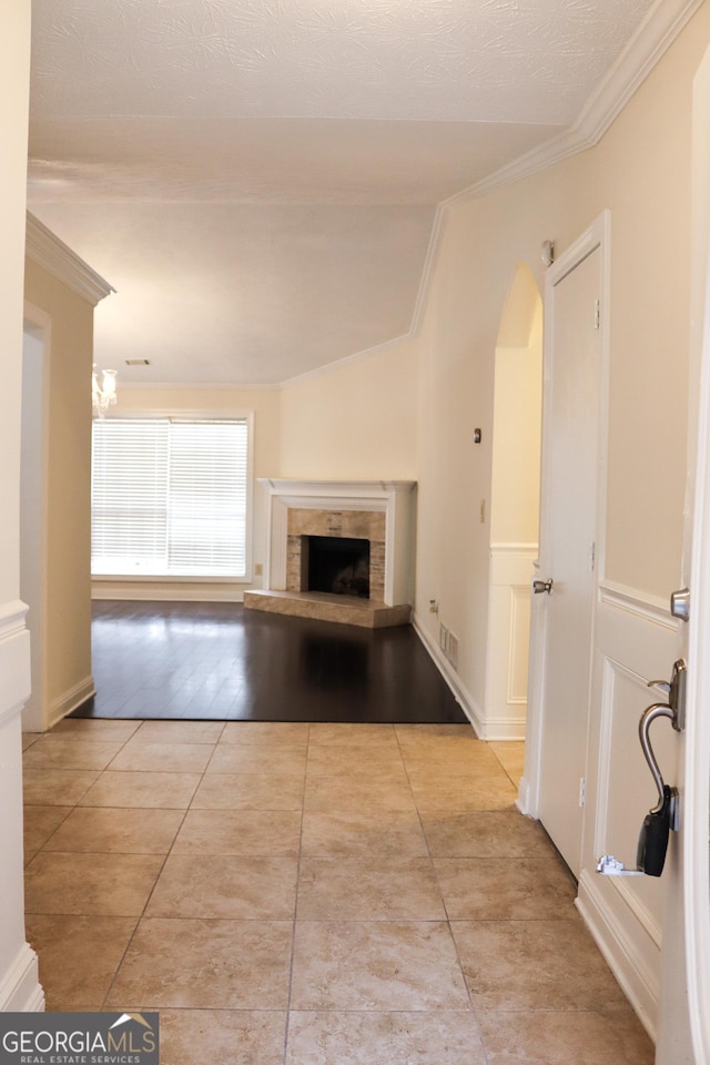 unfurnished living room featuring light tile patterned flooring and ornamental molding