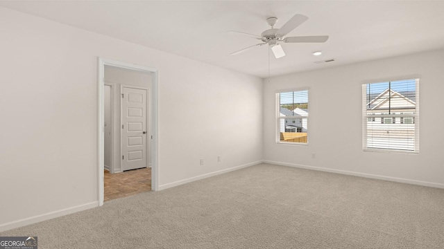 carpeted spare room featuring ceiling fan