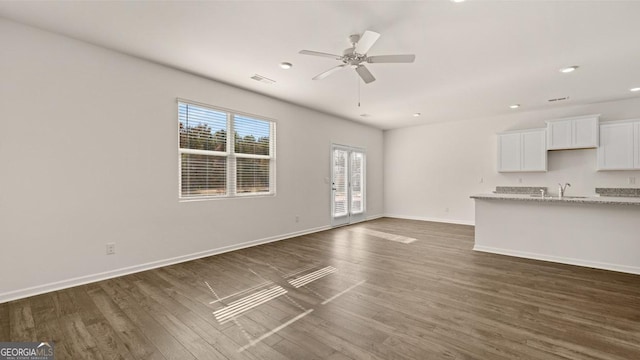 unfurnished living room featuring ceiling fan, dark wood-type flooring, and sink