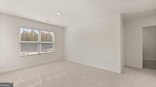 spare room featuring light colored carpet