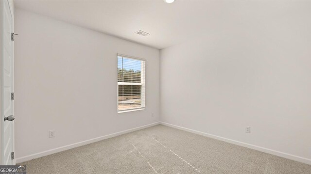 spare room featuring light colored carpet