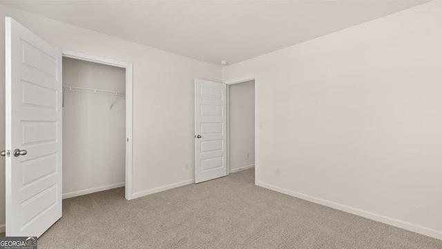 unfurnished bedroom with light colored carpet and a closet