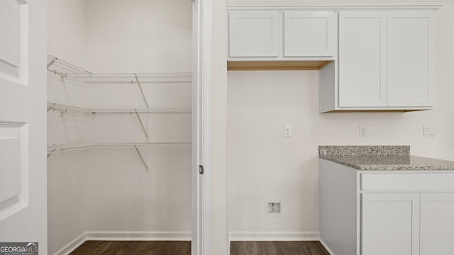 laundry area featuring dark wood-type flooring