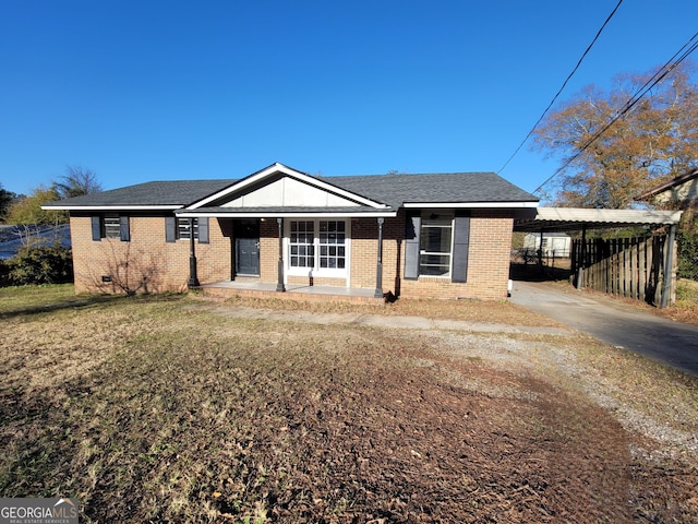 view of front of property featuring a front yard, a carport, and covered porch