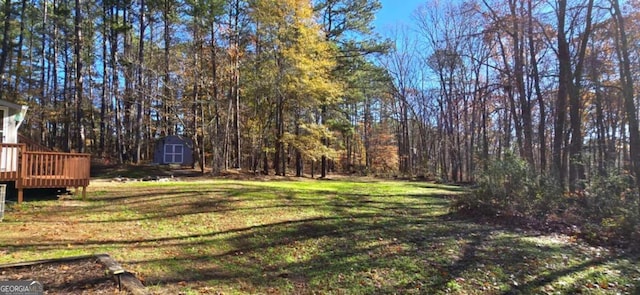 view of yard with a shed and a wooden deck