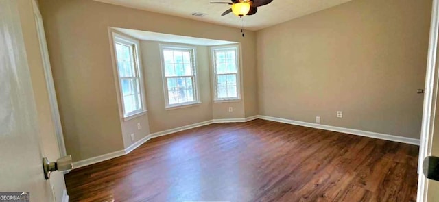 empty room with ceiling fan and dark hardwood / wood-style flooring