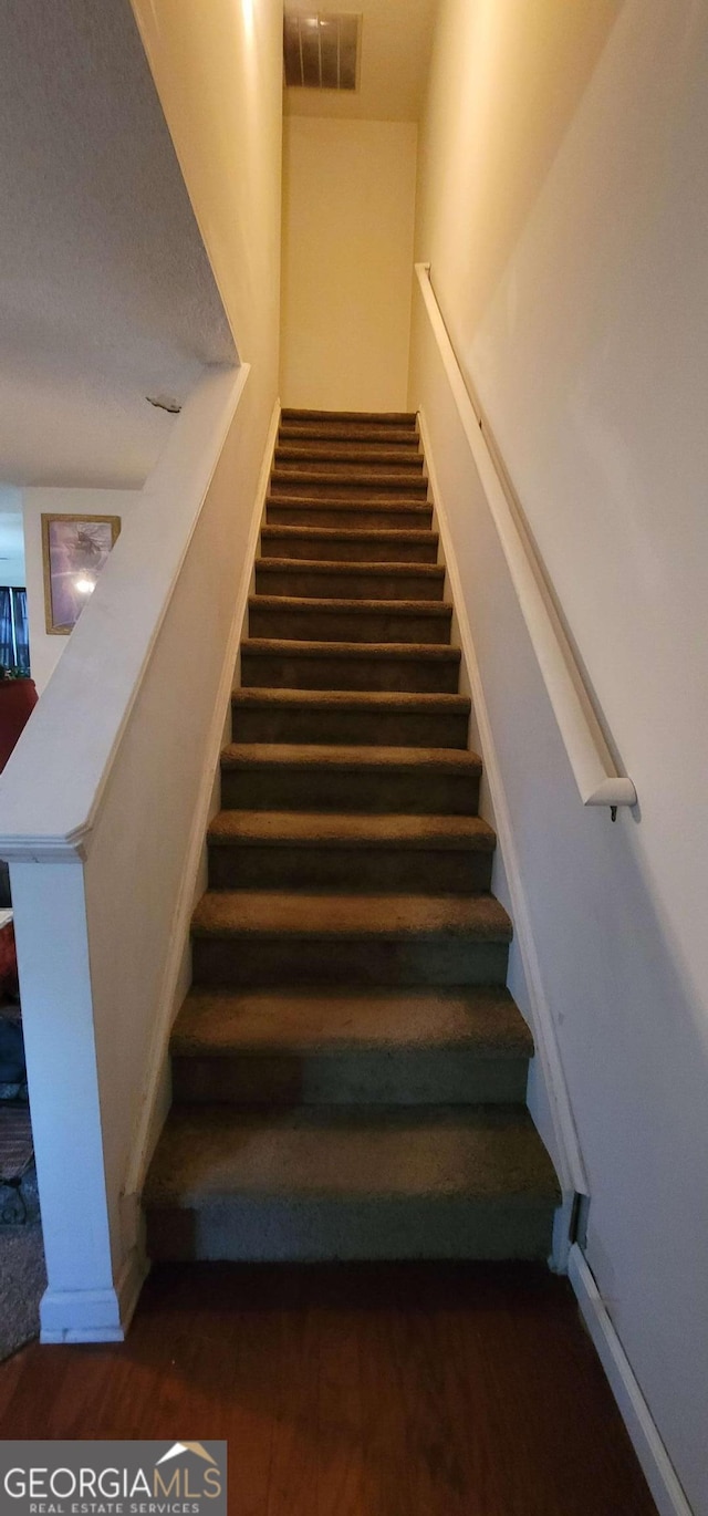 stairs featuring wood-type flooring