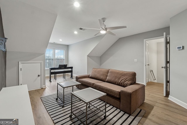 living room with lofted ceiling, ceiling fan, and light wood-type flooring