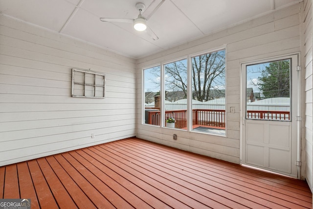 unfurnished sunroom with ceiling fan