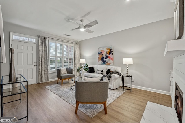 living room featuring ceiling fan and light hardwood / wood-style flooring