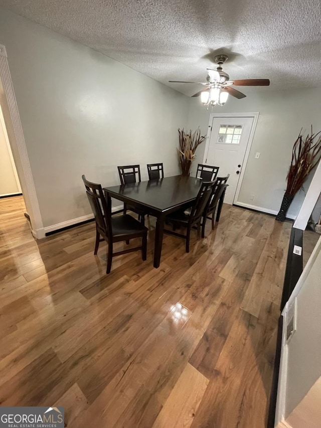 dining room with hardwood / wood-style floors and a textured ceiling