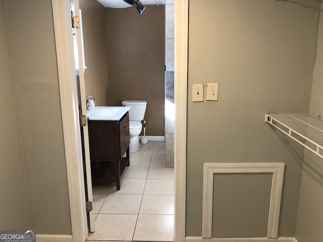 bathroom with toilet, vanity, and tile patterned floors