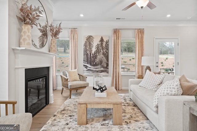 interior space featuring ceiling fan, ornamental molding, and light hardwood / wood-style flooring