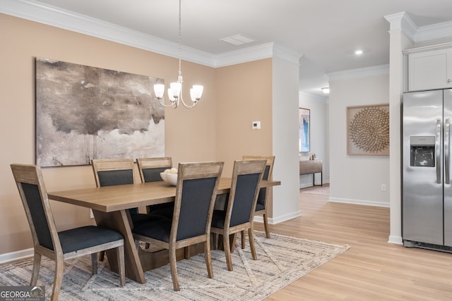 dining room with ornamental molding, light hardwood / wood-style flooring, and an inviting chandelier