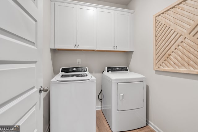 laundry area featuring cabinet space, baseboards, light wood-style floors, and independent washer and dryer