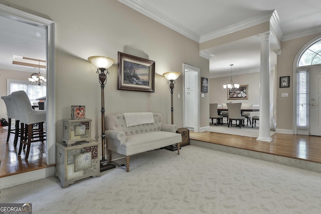 interior space featuring a healthy amount of sunlight, an inviting chandelier, ornamental molding, and decorative columns