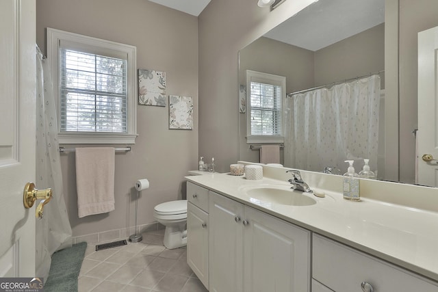 bathroom with tile patterned flooring, plenty of natural light, toilet, and vanity