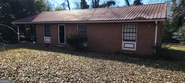 view of front of house featuring a carport and a front yard