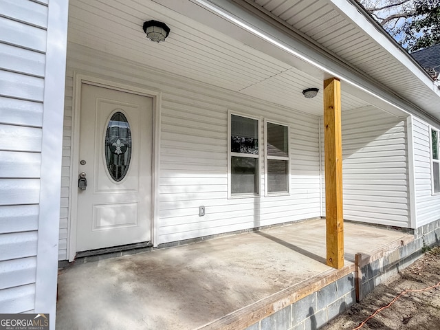 view of exterior entry featuring covered porch