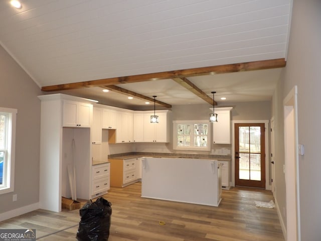 kitchen with light hardwood / wood-style floors, white cabinetry, hanging light fixtures, and a kitchen island