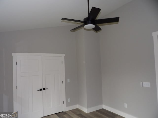 unfurnished bedroom featuring a closet, vaulted ceiling, ceiling fan, and dark wood-type flooring