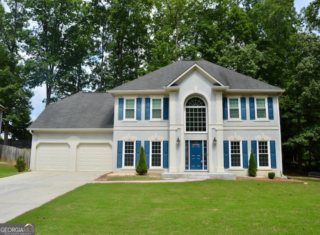 colonial inspired home with a front yard and a garage