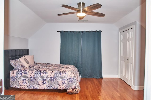 bedroom featuring ceiling fan, a closet, lofted ceiling, and hardwood / wood-style flooring