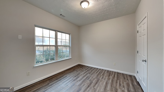 unfurnished room with hardwood / wood-style flooring and a textured ceiling