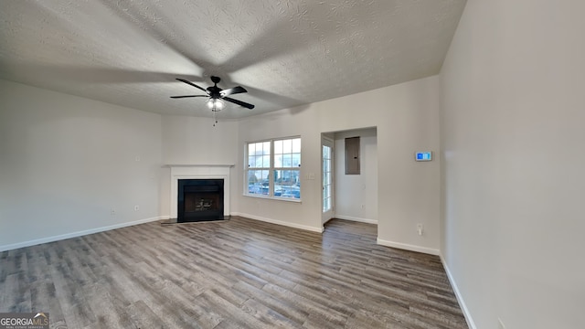 unfurnished living room featuring hardwood / wood-style flooring, ceiling fan, and a textured ceiling