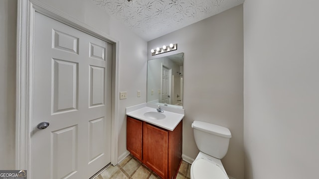 bathroom featuring vanity, a textured ceiling, and toilet