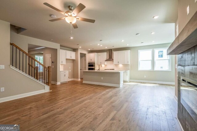 unfurnished living room featuring ceiling fan, sink, and light hardwood / wood-style flooring