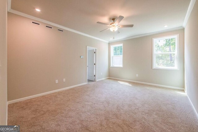 carpeted spare room with ceiling fan and ornamental molding