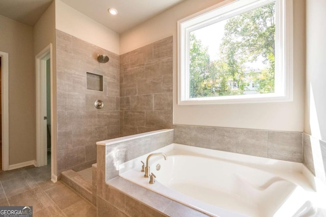 bathroom featuring plenty of natural light and separate shower and tub