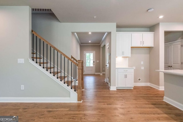 kitchen featuring light hardwood / wood-style floors, white cabinetry, and ornamental molding