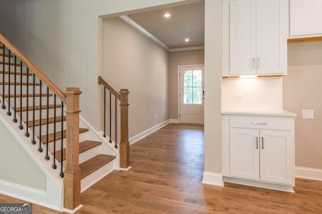 foyer entrance with wood-type flooring and ornamental molding