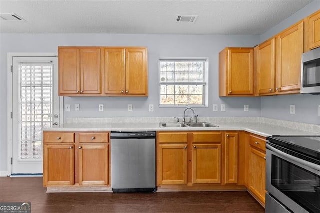 kitchen featuring dark hardwood / wood-style flooring, sink, stainless steel appliances, and a textured ceiling