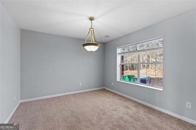 unfurnished room featuring a textured ceiling and light colored carpet