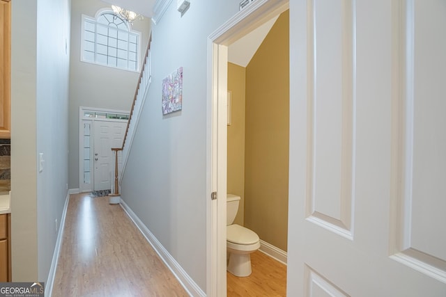 corridor featuring light hardwood / wood-style floors and a notable chandelier