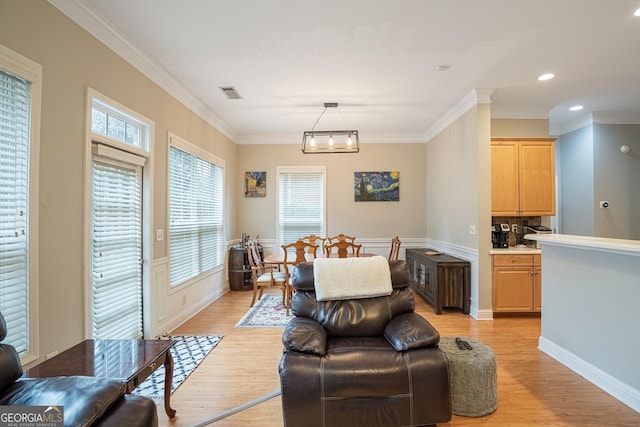 living room featuring a notable chandelier, light hardwood / wood-style floors, and ornamental molding