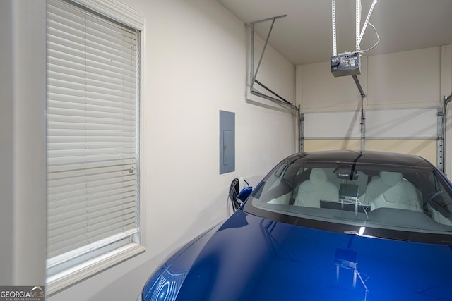 garage with a garage door opener and electric panel