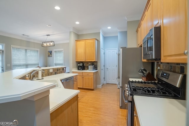 kitchen with pendant lighting, sink, stainless steel appliances, and ornamental molding