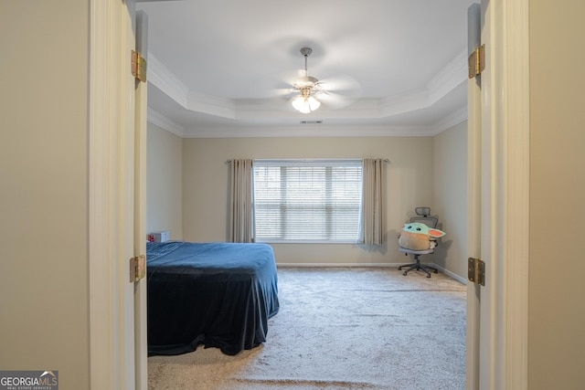 bedroom featuring a tray ceiling, ceiling fan, carpet floors, and ornamental molding