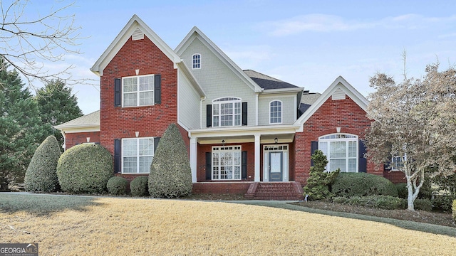 view of property with covered porch and a front yard