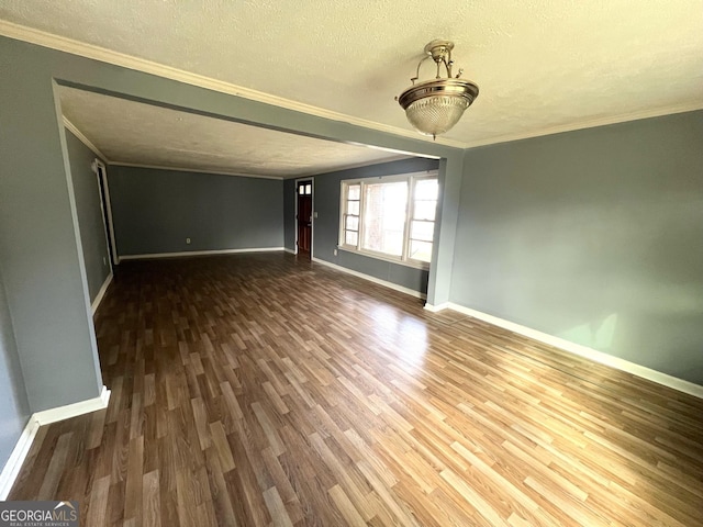 spare room with dark hardwood / wood-style floors, a textured ceiling, and ornamental molding