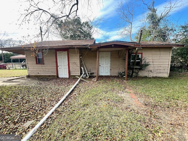 back of house featuring a yard and a carport