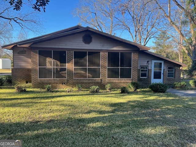 view of front of house with a sunroom and a front lawn